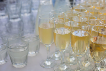 Beautiful row line of different colored alcohol cocktails with mint on a open air party, tequila, martini, vodka with bubbles,and others on decorated catering bouquet table on open air event, picture 