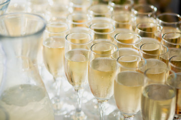 Beautiful row line of different colored alcohol cocktails with mint on a open air party, tequila, martini, vodka with bubbles,and others on decorated catering bouquet table on open air event, picture 