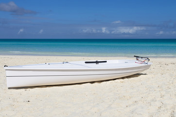 Fototapeta na wymiar Single white kayak on white sandy beach, Cayo Santa Maria, Cuba