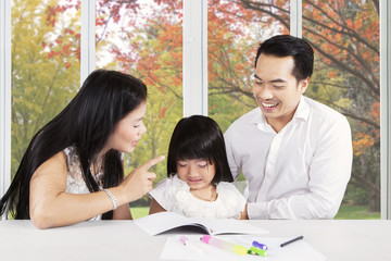 Fototapeta premium Father and mother advising their kid to learn
