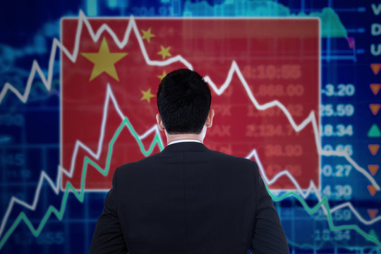 Man looking at a declining graph with chinese flag