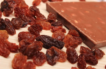 Nutritious chocolate with nuts and raisins on wooden table