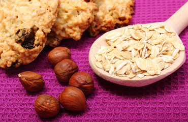 Oatmeal cookies with flakes and hazelnut on purple background