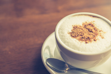 Hot latte art coffee on table ( Filtered image processed vintage