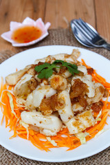 Fried squid serve with vegetable and sauce.