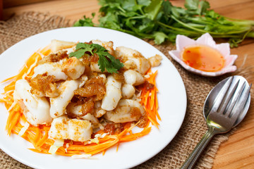 Fried squid serve with vegetable and sauce.