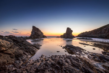 Fototapeta na wymiar Dramatic sunrise with mist on the beach with rocks.