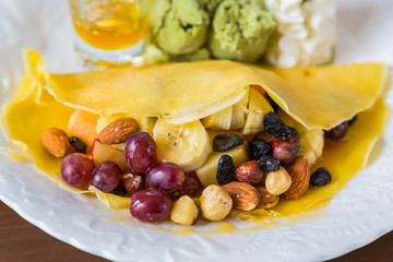 Pancake and fruit with ice cream on table