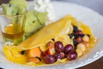 Pancake and fruit with ice cream on table