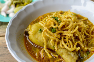 Thai Noodle Curry Soup with chicken on wooden table