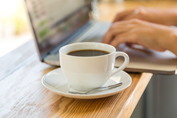 Coffee cup  with laptop on old wooden table
