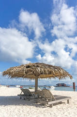Dreamy beach with sun loungers under a beach umbrella at Mabul, Semporna Sabah, Malaysia.