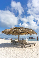 Dreamy beach with sun loungers under a beach umbrella at Mabul, Semporna Sabah, Malaysia.