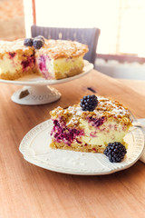 Piece of baked cake with fruit cream, set on wooden table in cafe.