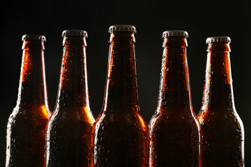 Glass bottles of beer on dark background