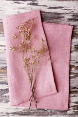 Beautiful dry flowers on napkin on wooden table close up