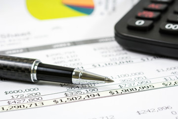 Black pen with financial report and calculator  