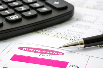 Black pen with financial report and calculator  