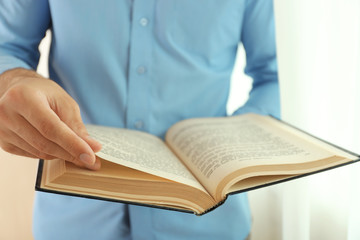 Young man reading book close up