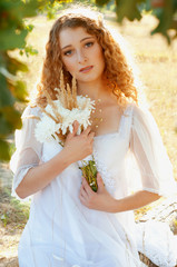 Woman with curly golden hair smiling standing in the field