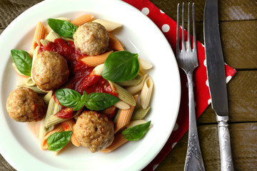 Pasta with meatballs on plate, on wooden  table background