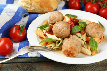Pasta with meatballs on plate, on wooden  table background