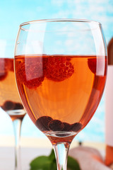 Closeup glasses of wine with berries on turquoise background