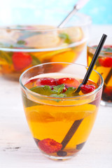 Fruity punch in glassware on wooden table, closeup