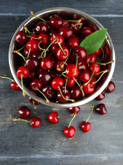 Naklejka na ściany i meble Fresh cherries in bowl on wooden background