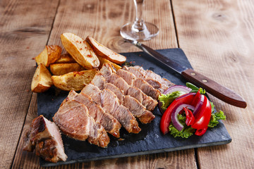 Sliced pork steak with fried potatoes