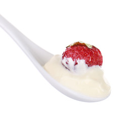 Delicious yogurt in spoon with strawberry isolated on white
