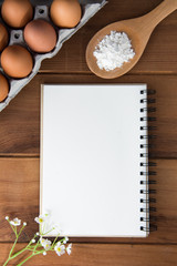Notebook white on a wooden floor with egg dishes.