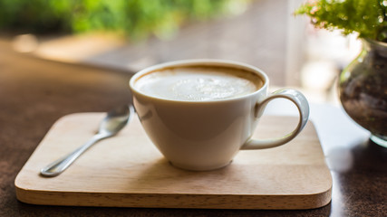 Hot latte art coffee on wooden table, vintage and retro style.