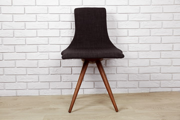 Modern chair on brick wall background
