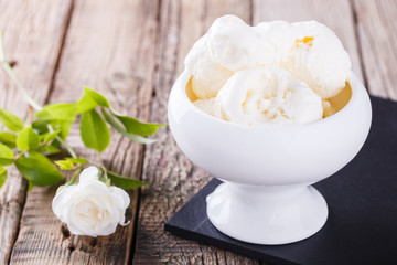 Ice cream, white cream in a white ceramic bowl with white roses.selective focus