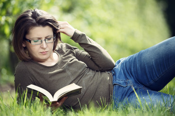 Woman reading a book in the orchard