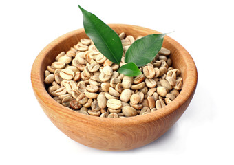 Green coffee beans with leaves in bowl isolated on white