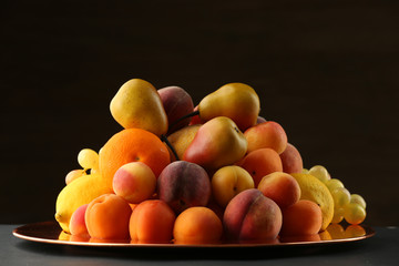 Heap of fresh fruits on dark background