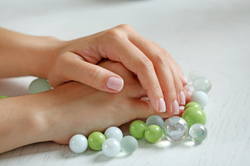 Woman hands with french manicure and glass beads on table close-up