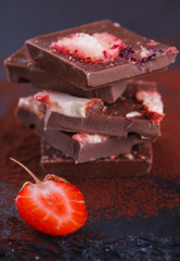 Stack of chocolate slices strawberry on a dark background.