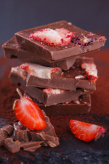 Stack of chocolate slices strawberry on a dark background.