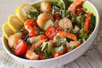 Fresh salad with shrimp, scallops and vegetables close up in a bowl. 
