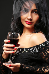 Pretty elegance woman with wineglass on black background