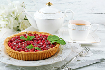 Tart with raspberries and tasty tea, on color  wooden background