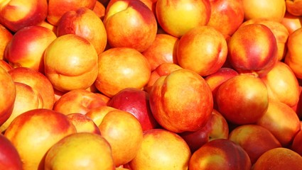 background of ripe nectarines for sale at vegetable market in su