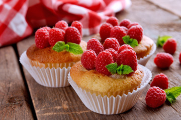 Delicious cupcakes with berries and fresh mint on wooden table close up