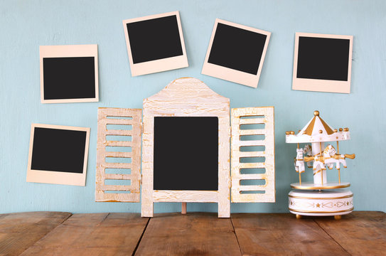 blank instant photos hang over wooden textured background next to blackboard