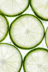 green lime slices and ice cubes, top view