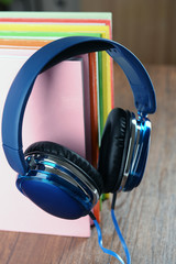 Books and headphones as audio books concept on wooden table, closeup