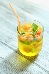 Glass of cold refreshing summer drink with berries and ice cubes on table close up